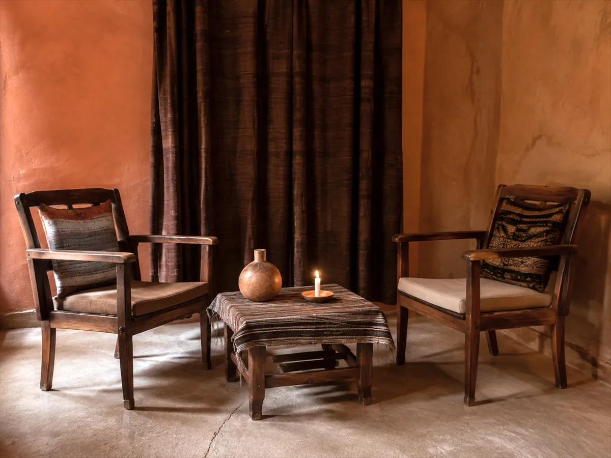 Salle de consultation avec deux fauteuils, une table basse et une bougie allumée