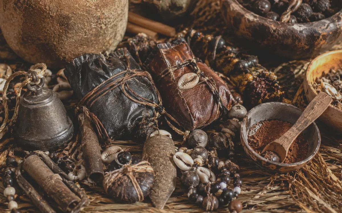 Gris-gris en cuir, cauris et perles disposés sur une natte